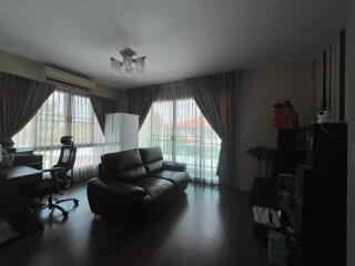 Living room with large windows and dark furniture