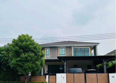 Two-story house with a balcony, garage, and surrounding greenery