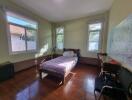 Bright bedroom with wooden flooring and single bed