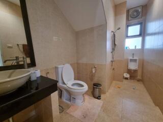 Spacious bathroom with toilet and urinal