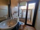 Modern bathroom with a sink, toilet, and shower area with glass door.