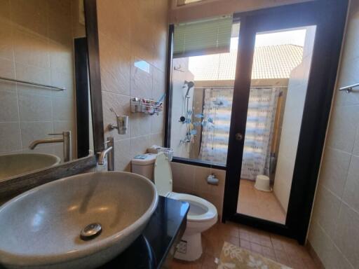 Modern bathroom with a sink, toilet, and shower area with glass door.