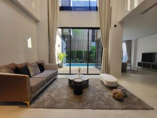 Modern living room with high ceiling and pool view