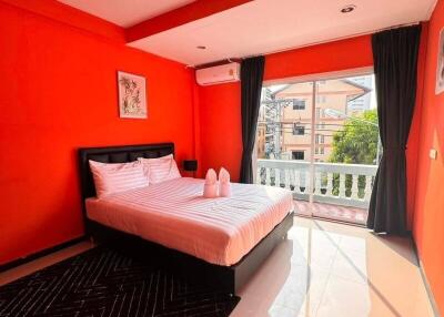 Bright bedroom with red walls and a large bed near a window