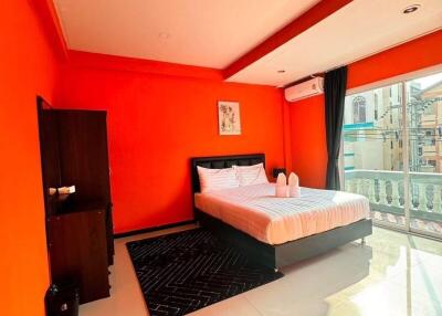 Bright and spacious bedroom with orange walls and large window