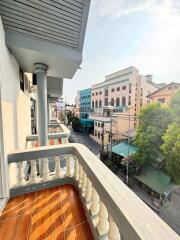 A view from the balcony overlooking the street with buildings and trees