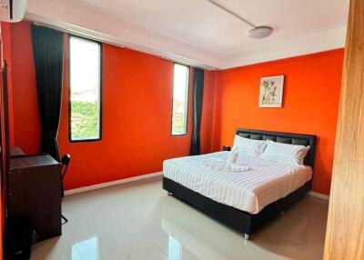 Bright Bedroom with Orange Walls and Large Windows