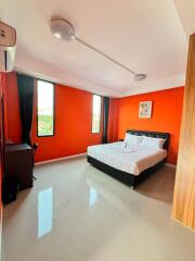 Bright Bedroom with Orange Walls and Large Windows