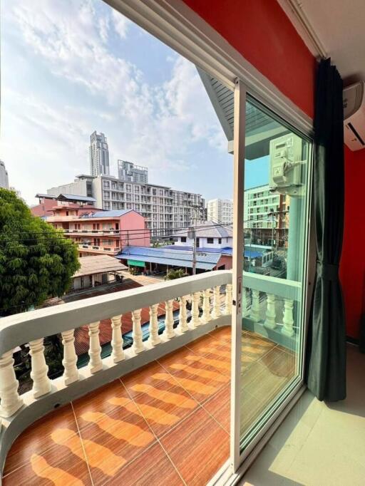 A balcony with a city view, featuring sliding glass doors and tiled flooring