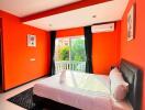 Bright bedroom with orange walls, large windows, and a bed