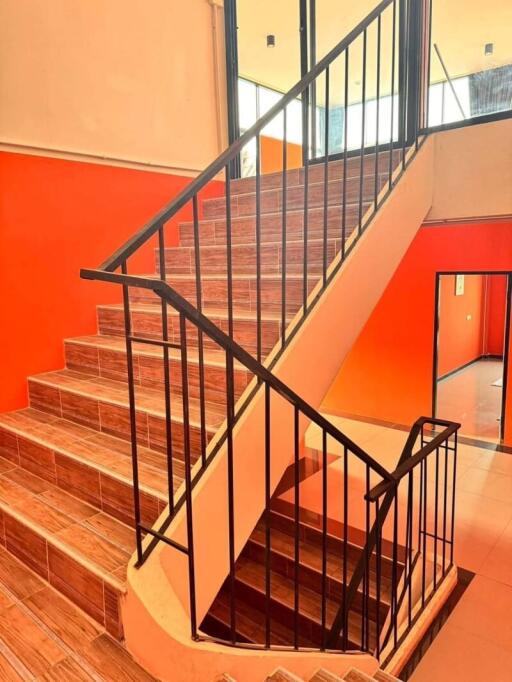 Staircase with black railings and wooden steps