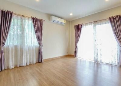 Spacious living room with large windows and wooden flooring