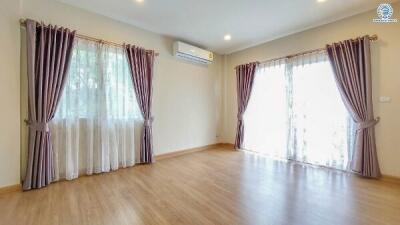 Spacious living room with large windows and wooden flooring