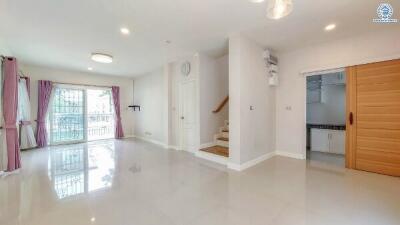 Spacious living room with large windows and staircase