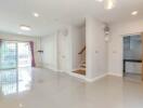 Spacious living room with large windows and staircase