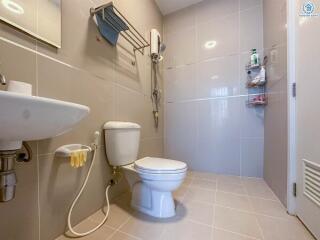 Modern bathroom with toilet, sink, and shower