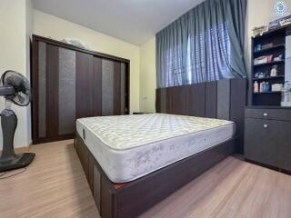 Bedroom with bed, wardrobe, fan, and shelving unit.