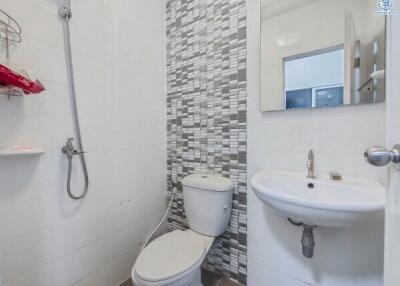 Modern bathroom with white fixtures and mosaic tile wall