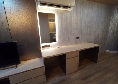 Modern bedroom with a built-in desk and wall-mounted air conditioning unit