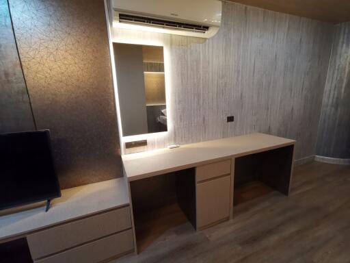 Modern bedroom with a built-in desk and wall-mounted air conditioning unit