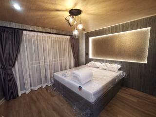 modern bedroom with double bed, hanging lights, and large window