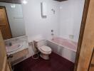 Bathroom with white tile walls, a bathtub, toilet, sink, and wooden ceiling.