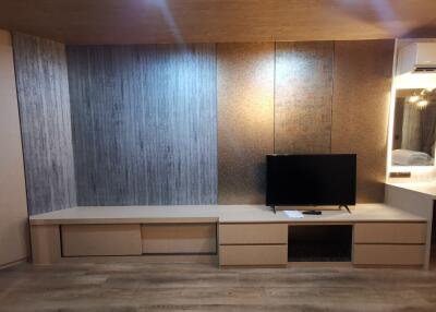 Modern living room with a wall-mounted TV and wooden flooring