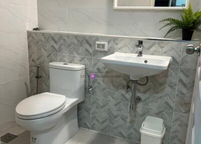 Modern clean bathroom with white toilet, sink, and mirror