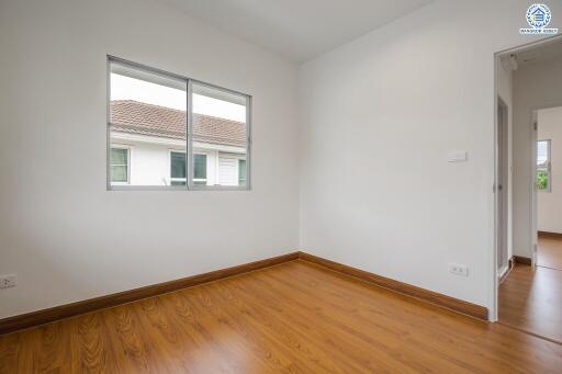 Empty bedroom with large window and wooden floor