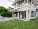 Exterior view of a modern two-story house with a well-maintained lawn.