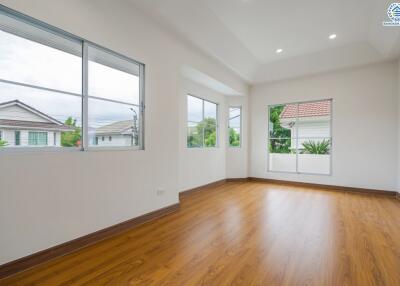 Spacious living room with large windows and hardwood flooring