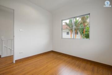 Empty bedroom with wooden floors and a window