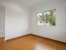 Empty bedroom with wooden floors and a window