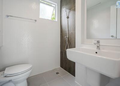 Modern bathroom with toilet, sink, and shower