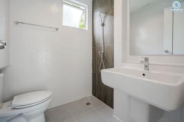 Modern bathroom with toilet, sink, and shower