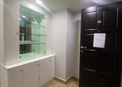 entryway with wooden door and glass cabinet