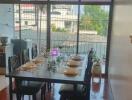 Dining area with table set for six next to a large window