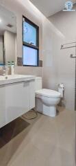 Modern bathroom with white fixtures and a large mirror