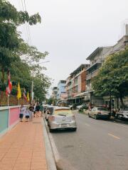 Street view of residential area with parked cars and pedestrians