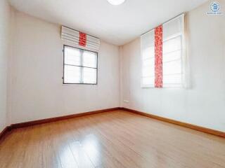 Empty bedroom with wooden flooring and windows with blinds