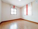 Empty bedroom with wooden flooring and windows with blinds