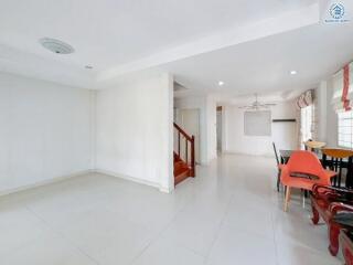 Spacious living room with adjacent dining area and staircase