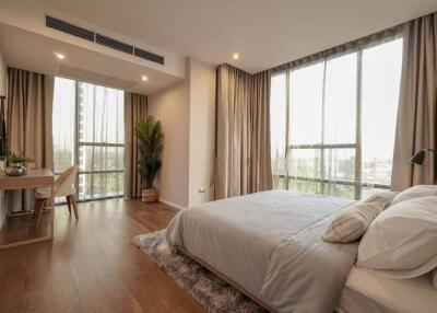 Spacious and well-lit bedroom with wooden flooring and a comfortable double bed
