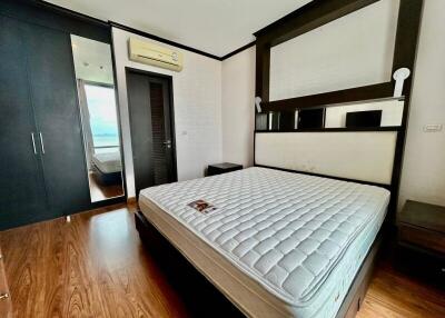 Modern bedroom with wooden flooring and queen size bed