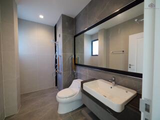 Modern bathroom with shower, toilet, and large mirror