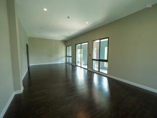 Spacious living area with wooden floors and large windows