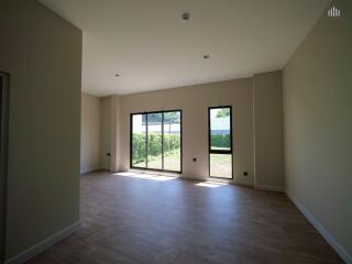 Spacious living room with large windows and wooden flooring