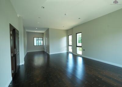 Spacious and bright living room with dark wood floors and large windows