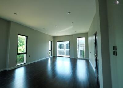 Spacious living room with dark wood flooring and large windows