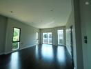 Spacious living room with dark wood flooring and large windows